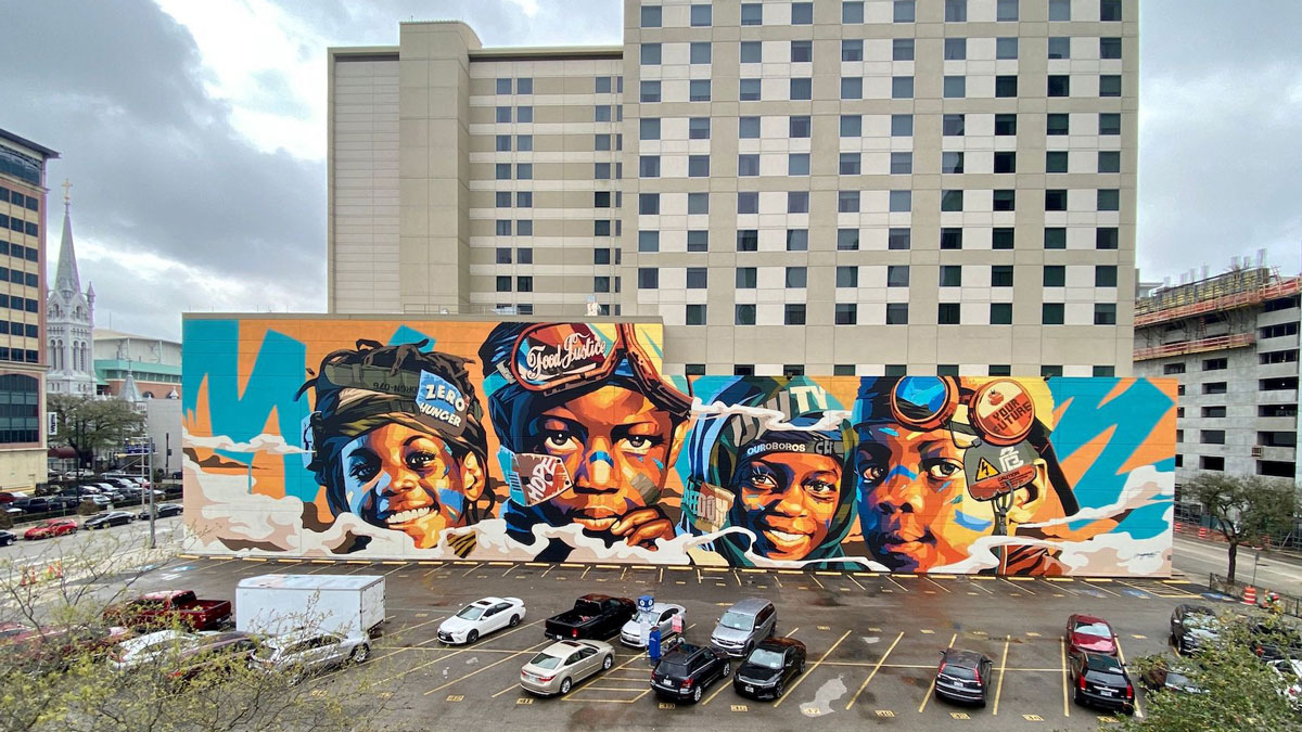 Cuatro caras de niños en un colorido mural en una pared en un estacionamiento en Houston, Texas.