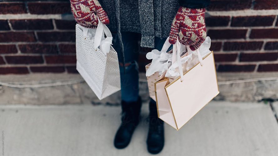 Persona sosteniendo bolsas de temporada de compras navideñas